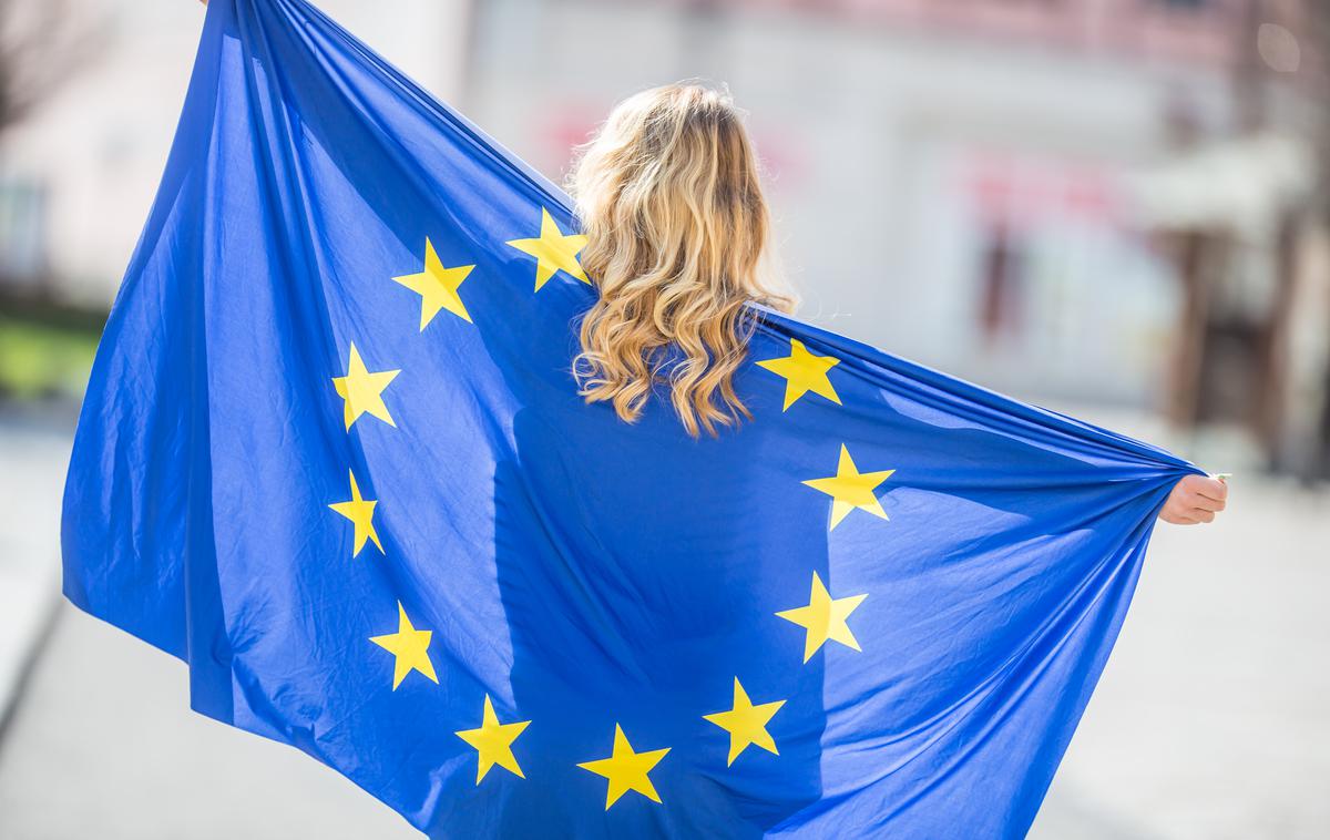 Ženska z zastavo EU. | V povezavi je bilo na začetku šest držav (Belgija, Francija, Italija, Luksemburg, Nizozemska in Zahodna Nemčija), nato se je večkrat širila, v okviru največje širitve 1. maja 2004 je vanjo s še devetimi državami vstopila Slovenija.  | Foto Shutterstock