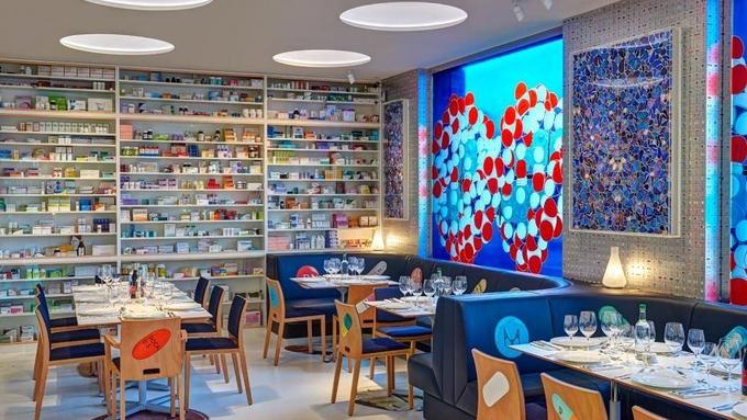 Damien Hirst je umetnik, ki je tudi uspešen podjetnik. Restavracija Pharmacy, ki jo je zasnoval v svoji londonski galeriji, spominja na lekarno, s čimer je skozi interjer želel podati komentar sodobnega položaja farmacije (foto: www.pharmacyrestaurant.com). | Foto: 