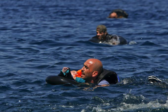 Sirski begunec z dojenčkom v rešilnem obroču plava proti obali, potem ko je njihov čoln spustil okoli sto metrov pred grškim otokom Lezbos, 13. september 2015. | Foto: Reuters