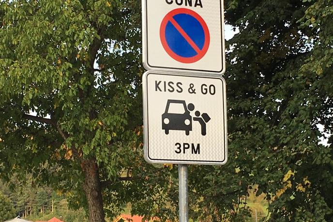 znak | Člani SAZU protestirajo proti po njihovem mnenju pretirani rabi angleščine. V Zrečah stoji znak 'Kiss and go', poljubi in pojdi. Označuje tri parkirna mesta, kjer lahko starši ustavijo, otroci pa varno izstopijo iz vozila in odidejo v šolo.