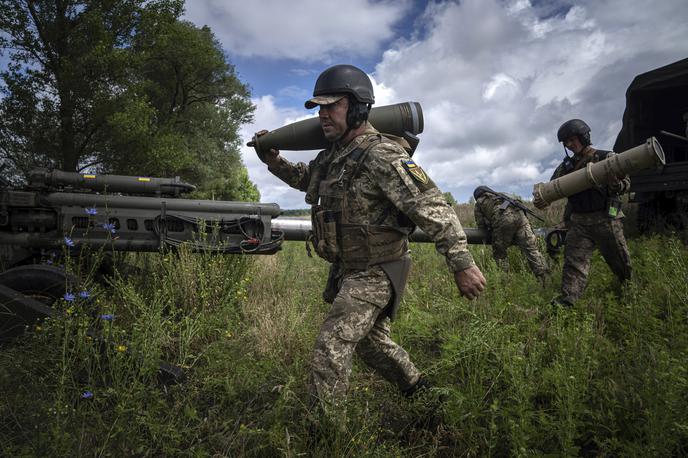 Ukrajina, vojaki | Ukrajinski vojak med prenašanjem 155-milimetrskega izstrelka, ki je bil kasneje sprožen proti ruskim položajem v bližini Harkova, julij 2022 | Foto Guliverimage