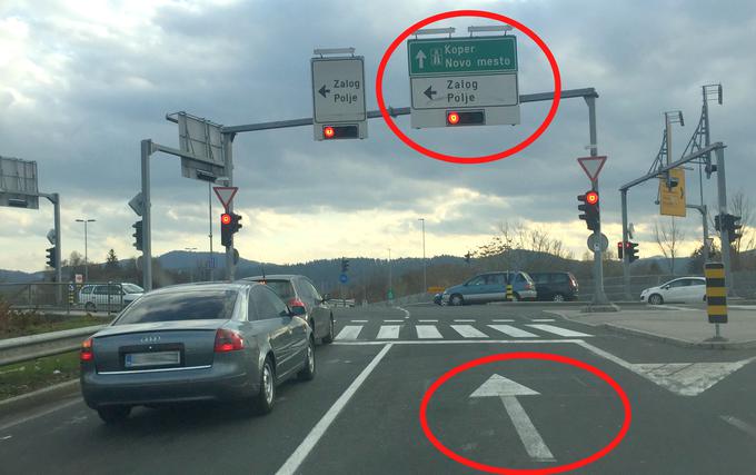 Prometna oznaka nad cesto predvideva zavijanje v levo, talna oznaka pa le vožnjo naravnost.  | Foto: Gregor Pavšič