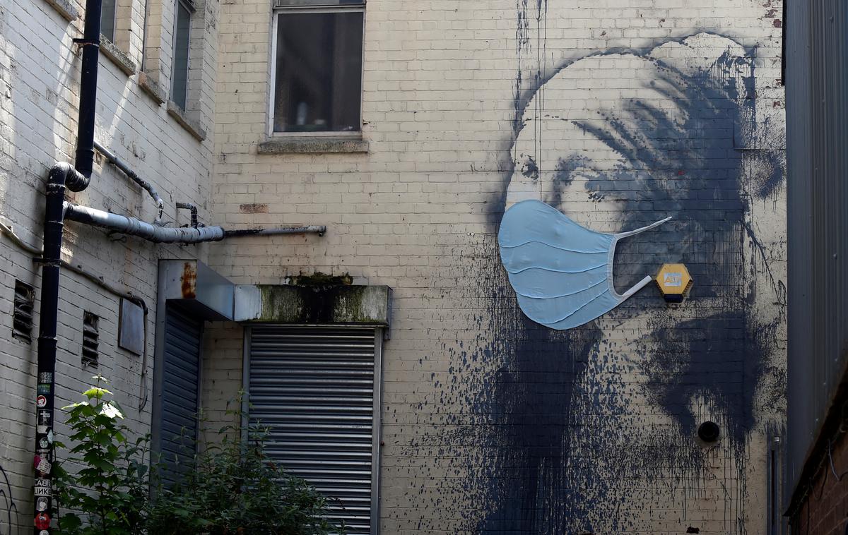 Banksy deklica | Tudi Banksyjevo dekle te dni nosi masko. | Foto Reuters