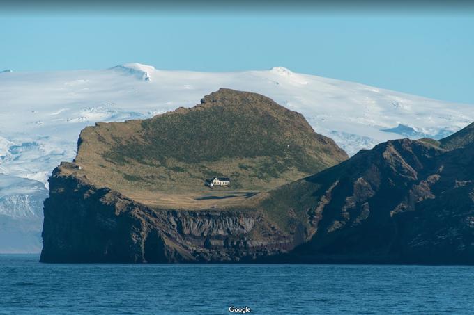 V ospredju zaliv, pred katerega je mogoč dostop do hiše na otoku. V ozadju zasnežena Islandija. Kot je razvidno s te fotografije, je otok Ellidaey sicer precej gol, saj na njem ni dreves, le travniki in skale. |  Foto: Google Maps | Foto: 