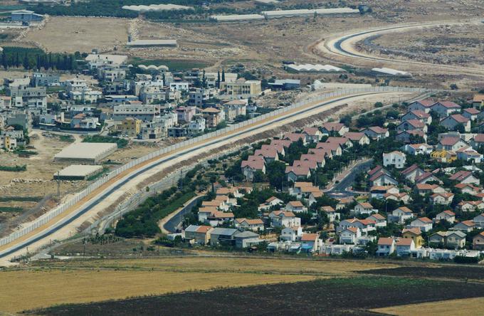 Zid, ki na zasedenem Zahodnem bregu ločuje izraelsko naselje od palestinske vasi. Palestinska vas je levo od zidu, na desni je izraelsko naselje. | Foto: Guliverimage
