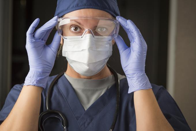 Med obvezno zaščitno opremo zdravstvenih delavcev med drugim sodijo rokavice, maska in očala. | Foto: Getty Images