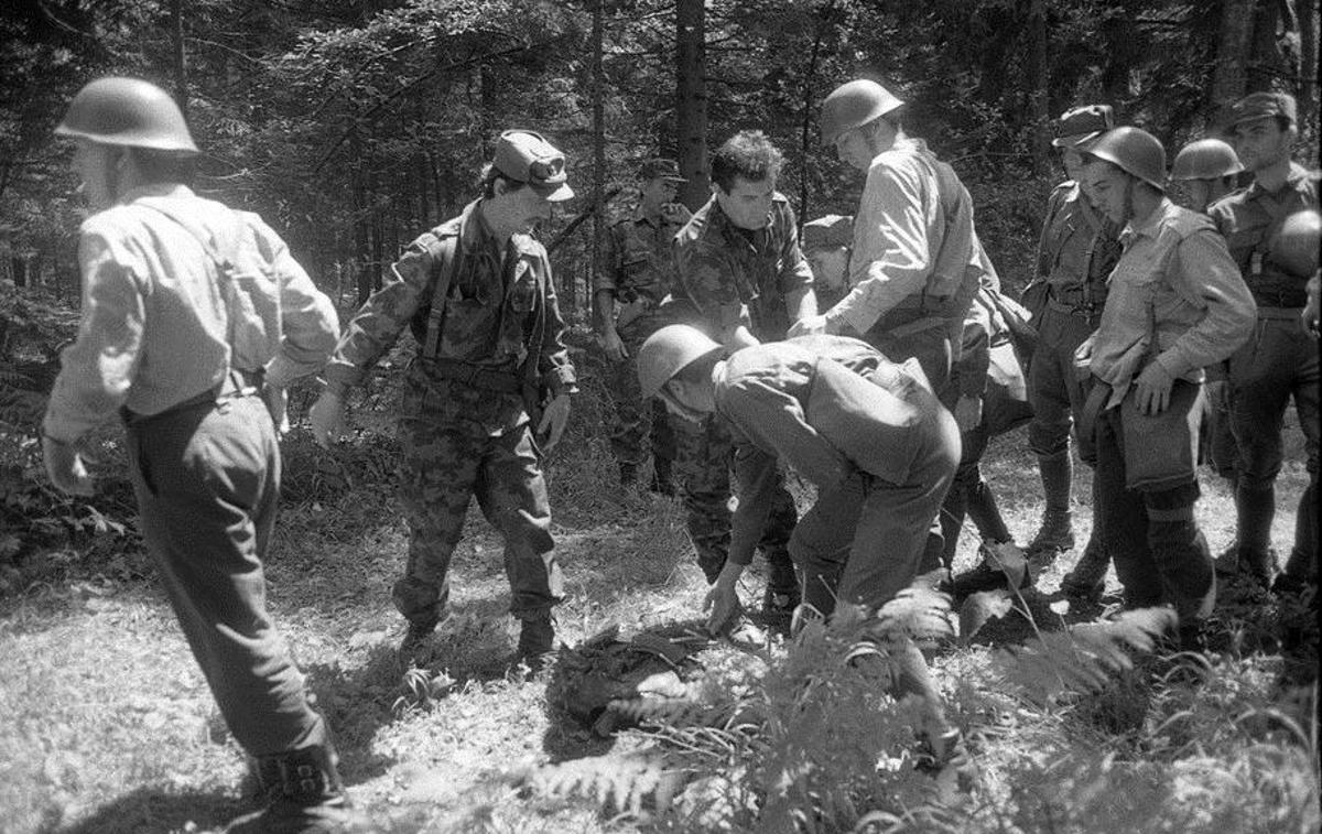 Slovenski teritorialci razorožujejo vojake JLA | Slovenija je samostojnost razglasila 25. junija, že naslednji dan pa so se prvi jugoslovanski tanki valili proti mejnim prehodom na meji z Italijo. Vsesplošni napad JLA na Slovenijo se je začel 27. junija. Napad JLA se je izjalovil, saj so slovenske sile v desetih dneh uspešno ubranile slovensko državo. Na fotografiji: vojaki JLA se predajajo slovenskim teritorialcem. | Foto Tone Stojko, hrani Muzej novejše zgodovine Slovenije