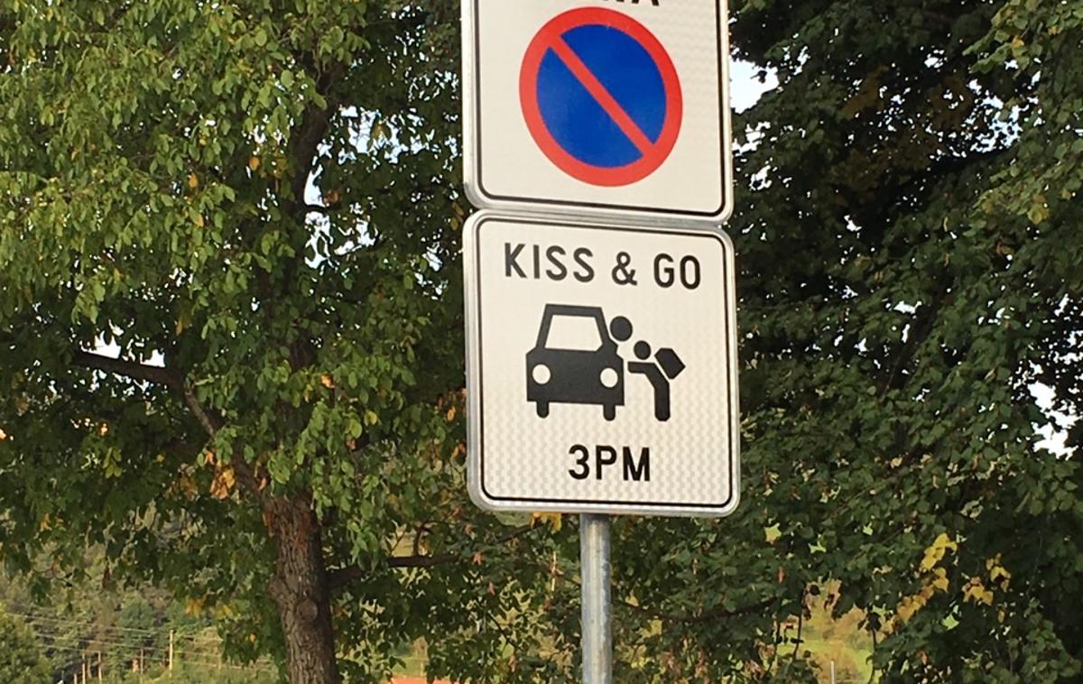 znak | Člani SAZU protestirajo proti po njihovem mnenju pretirani rabi angleščine. V Zrečah stoji znak 'Kiss and go', poljubi in pojdi. Označuje tri parkirna mesta, kjer lahko starši ustavijo, otroci pa varno izstopijo iz vozila in odidejo v šolo.