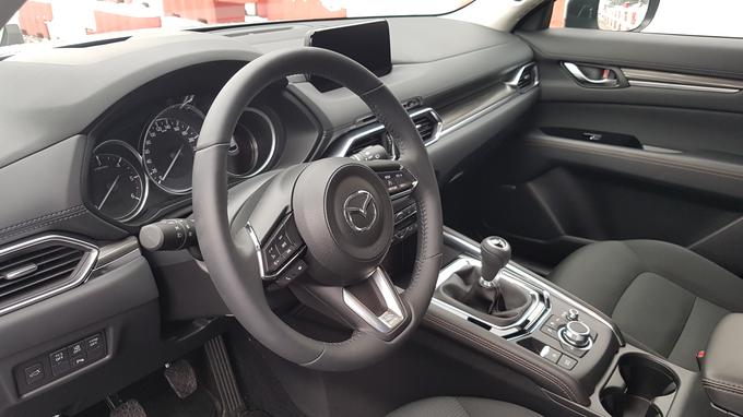 Mazda ima na sredinskem grebenu okrogel gumb za nadzor infozabavnega vmesnika, saj zaslon med vožnjo ni občutljiv na dotik. Hvalimo skrb za prometno varnost. Tak vrtljiv gumb poznamo predvsem iz premium razreda. | Foto: Gregor Pavšič
