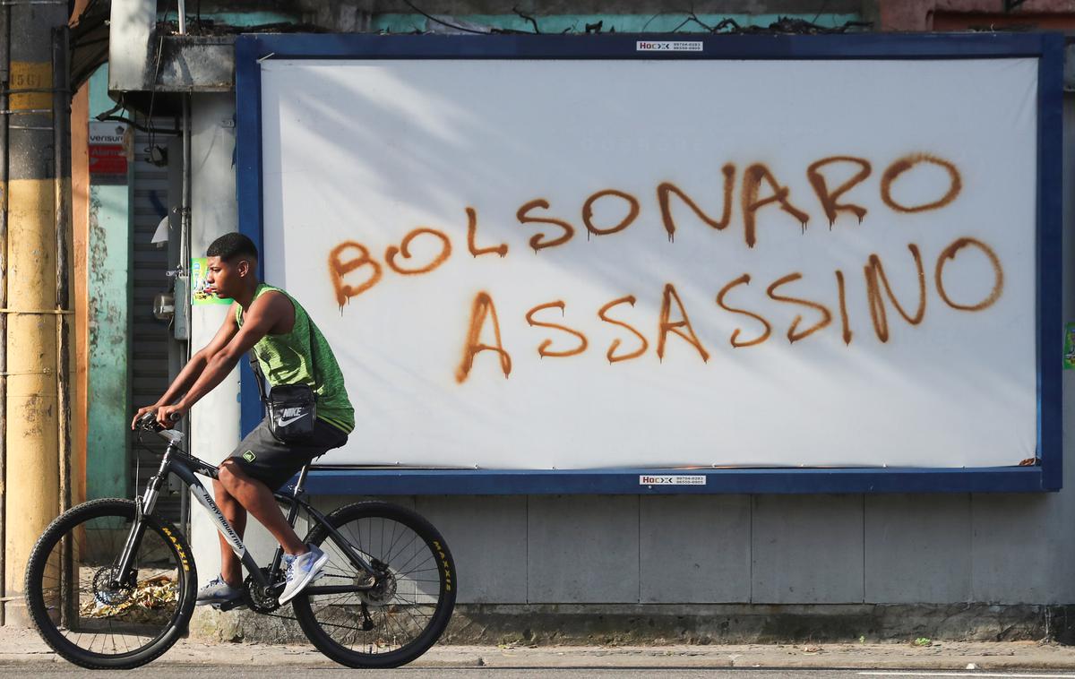 Brazilija koronavirus | "Bolsonaro morilec" piše na grafitu, uperjenem proti brazilskemu predsedniku. | Foto Reuters
