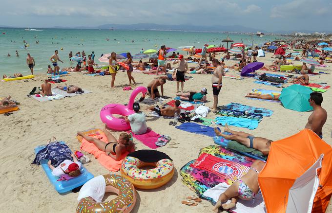 Tudi ob počivanju na plaži je pomembno skrbeti za ohranjanje varne razdalje vsaj poldrugega metra, česar ljudje ponekod le nimajo v mislih. | Foto: Reuters