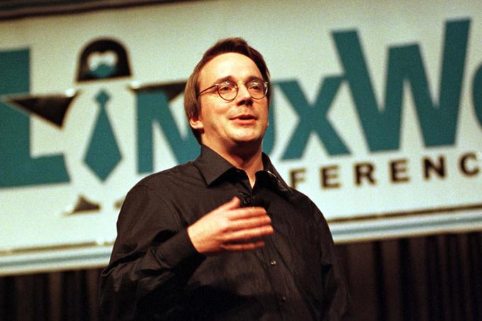 Linus Torvalds leta 1999 na prvem mednarodnem zborovanju programerjev LinuxWorld, konferenci, namenjeni izključno pogovorom o Linuxu. Zadaj levo silhueta pingvina, ki je skozi leta postal zaščitni znak operacijskega sistema. | Foto: Reuters