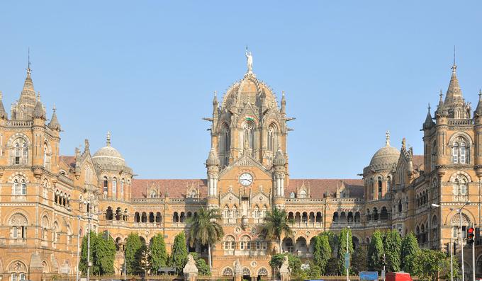 Včasih poznana kot postaja Victoria Terminus v Mumbaju predstavlja preplet viktorijanske in tradicionalne indijske arhitekture. Postaja, v katero je bilo vloženega veliko dela, je bila končana leta 1888, nastajala pa je deset let. Arhitekt F. W. Stevens je na njenem pročelju zasnoval okrasne kamne in skulpture lokalne flore in favne ter kipe, ki ponazarjajo lokalne kaste in skupnosti. | Foto: Wikipedia