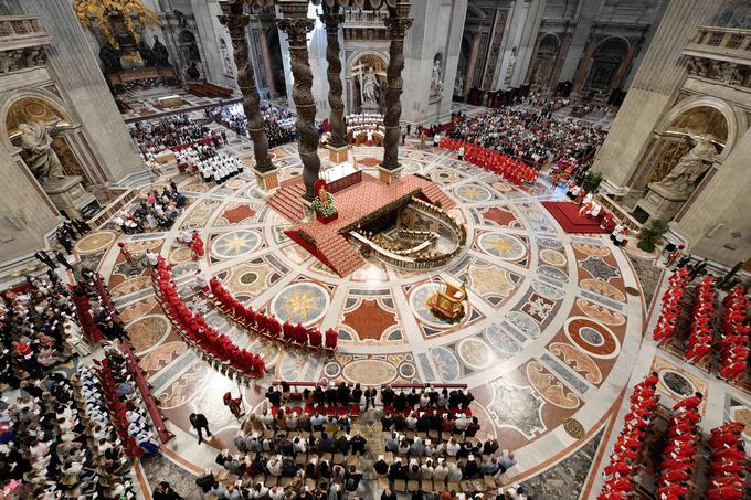 V klopeh in na stolih okoli oltarja v baziliki je sedelo več sto vernikov in kardinalov.  | Foto: Reuters