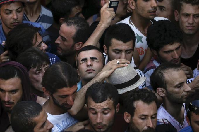 Sirski begunec poskuša priti do zraka v množici pred registracijo na štadionu grškega otoka Kos, 12. avgust 2015. | Foto: Reuters