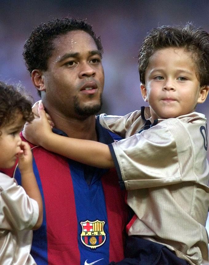 V naročju (levo) slovitega očeta Patricka Kluiverta leta 2001, ko je ta igral za Barcelono. | Foto: Reuters