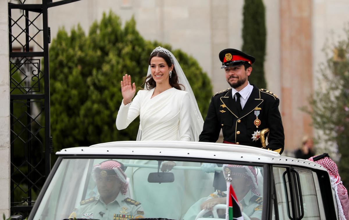 poroka jordanskega princa | 28-letna Radžva je nosila dolgo belo obleko libanonskega modnega oblikovalca Elieja Saaba z dolgimi rokavi, tiaro in dolgo vlečko. Ženin pa je bil oblečen v slavnostno vojaško uniformo, podobno tisti, ki jo je na svoji poroki nosil njegov oče, poroča nemška tiskovna agencija dpa. | Foto Reuters