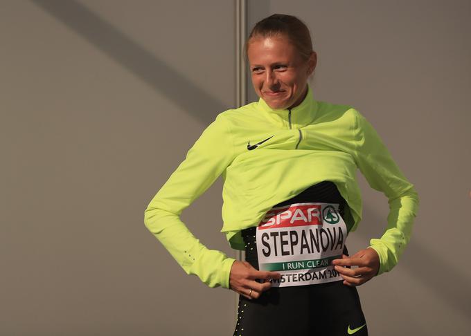 Ruska tekačica Julija Stepanova pred nastopom na evropskem prvenstvu v Amstredamu pri nameščanju štartne številke, na kateri piše "tečem čista". | Foto: Getty Images