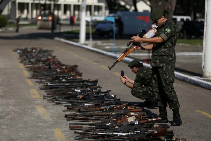 Brazilske tolpe so do zob oborožene. Na fotografiji: policisti ob orožju, ki so ga zaplenili kriminalcem. | Foto: Reuters
