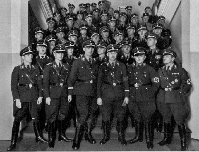 SS ali Schutzstaffel je bila elitna paramilitaristična organizacija nacistične Nemčije, ki je odgovarjala neposredno Adolfu Hitlerju. Na fotografiji častniki SS - v prvi vrsti tretji z desne (z očali) je Heinrich Himmler, prvi mož organizacije. | Foto: 
