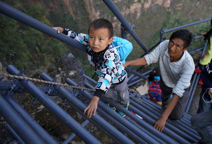Učenci vasi v Atuleerju se na poti do šole vzpenjajo po novih jeklenih lestvah. | Foto: Reuters