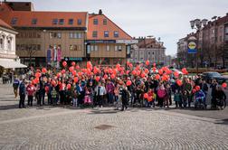 V več krajih po Sloveniji poteka pohod z rdečimi baloni