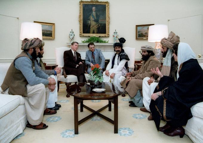 V času hladne vojne so afganistanski mudžahidi veljali za bojevnike za svobodo in ameriške zaveznike. A protisovjetsko zavezništvo med islamisti in Zahodom oziroma ZDA je po odhodu sovjetske vojske iz Afganistana hitro postalo preteklost. Na fotografiji: ameriški predsednik Ronald Reagan se v Beli hiši pogovarja z afganistanskimi mudžahidi. | Foto: Thomas Hilmes/Wikimedia Commons