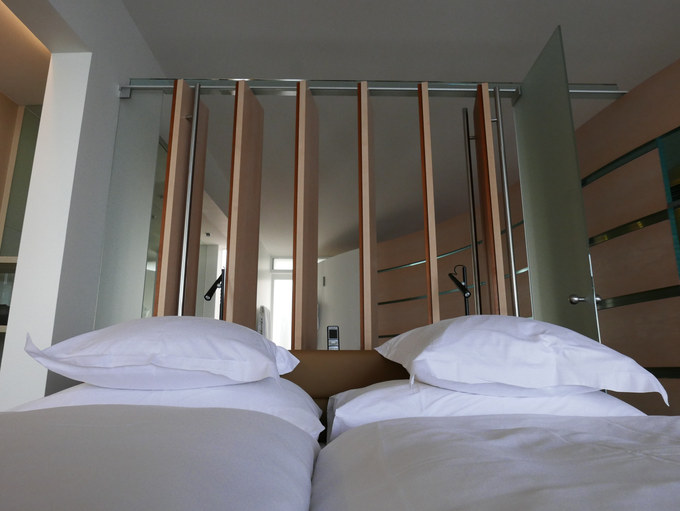 Spalni prostor je od kopalnice ločen z leseno pregradno steno, ki jo lahko odprete ali zaprete. | Foto: Metka Prezelj