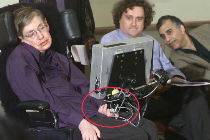 Stephen Hawking leta 2001. V levi roki drži stikalo, ki ga je uporablja za izbiranje besed in tvorjenje besednih zvez na zaslonu, ki je bil nameščen na njegov invalidski voziček.  | Foto: Reuters