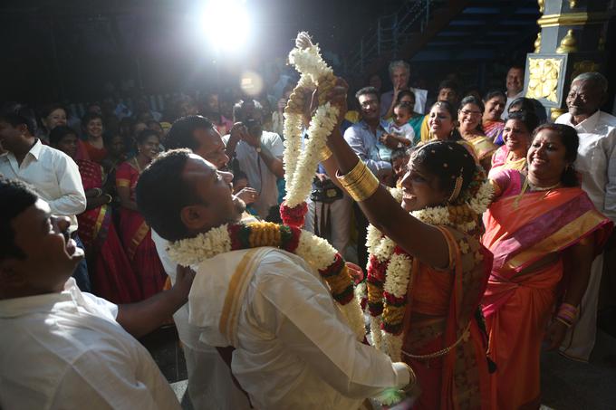 Poročno slavje je v Indiji bogato. Del tradicije je tudi, da poskuša žena dati možu venec okoli glave, mož pa se ji pri tem izmika. | Foto: Osebni arhiv