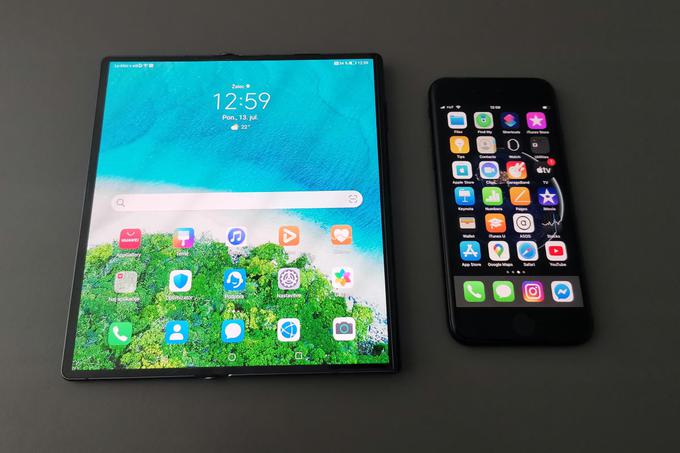 Pametni telefon Huawei Mate Xs je v razprtem stanju zelo velik, morda je celo največji pametni telefon na slovenskem trgu. Za primerjavo velikosti je na tej fotografiji zraven novi iPhone SE, ki pa je eden najmanjših pametnih telefonov ta hip.  | Foto: Matic Tomšič