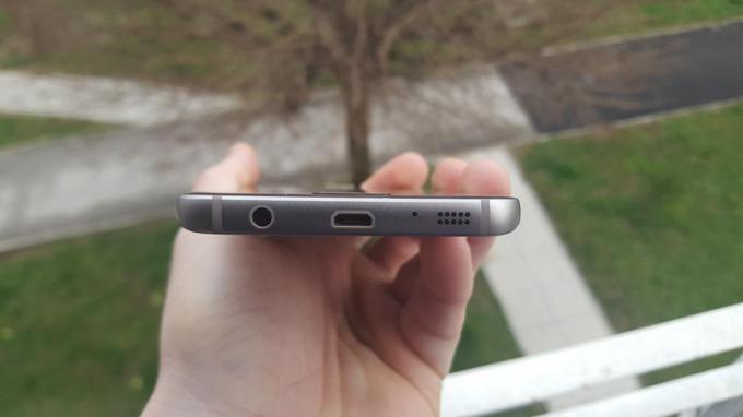 Tole je spodnji rob pametnega telefona Galaxy S7, ki še ima priključek za slušalke (levo), za polnjenje baterije in prenos podatkov pa še vedno uporablja tudi priključek microUSB (sredina). Oba bosta po poročanju SamMobile pri naslednji generaciji telefona Galaxy Sx združena v en priključek, USB-C.  | Foto: Matic Tomšič