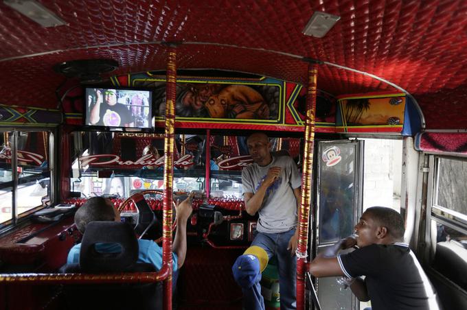 Voznik avtobusa med kratkim počitkom gleda televizijo. Tudi notranjost je nakičena, kot si je v Evropi skoraj predstavljati ne moremo. | Foto: Reuters