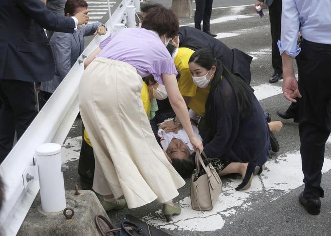 Japonski mediji, ki jih navaja francoska tiskovna agencija AFP, poročajo, da je prvi strel verjetno zgrešil cilj, a mu je sledil še drugi, po katerem je 67-letni politik padel na tla, krvavel naj bi iz vratu. | Foto: Reuters