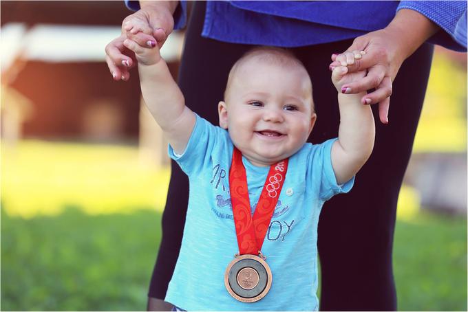 Originalno olimpijsko medaljo hrani doma (na fotografiji jo nosi njen sin Val Luka), kopije pa so v pisarni Marjana Fabjana in prostorih sponzorjev. (Foto: Sonja Brcar). | Foto: 