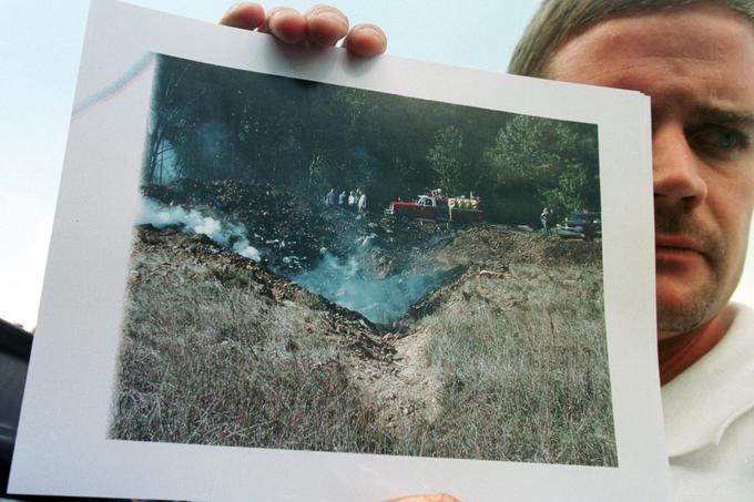 Eden od fotografov mesta nesreče leta United 93 v roki drži fotografijo, ki jo je posnel kmalu po strmoglavljenju letala. To je v tla treščilo s hitrostjo več kot 900 kilometrov na uro in izdolblo tri metre globok krater. | Foto: Reuters