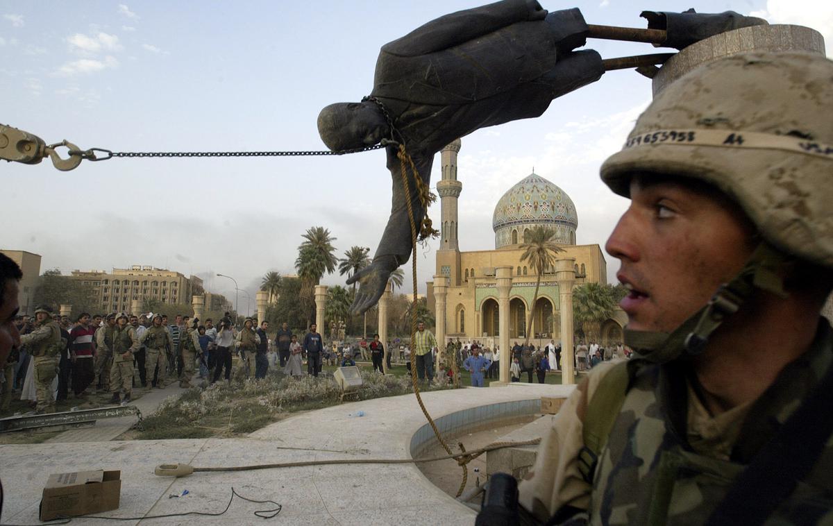 Ameriški vojak v Bagdadu | Ameriški vojaki so že 9. aprila 2003 vstopili v iraško prestolnico Bagdad. Na fotografiji: Iračani, ki so nasprotovali Sadamovemu režimu, rušijo kip Sadama Huseina v Bagdadu. | Foto Guliverimage