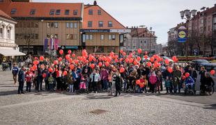 V več krajih po Sloveniji poteka pohod z rdečimi baloni