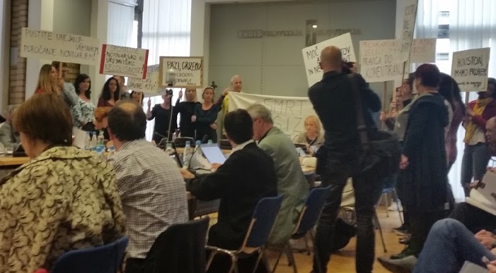 Sivolasi mož, ki na levi strani drži transparent s pozivom k smrti, je eden od pomembnih obrazov levih protestov ob petkih Igor Bricelj. | Foto: Peter Jančič