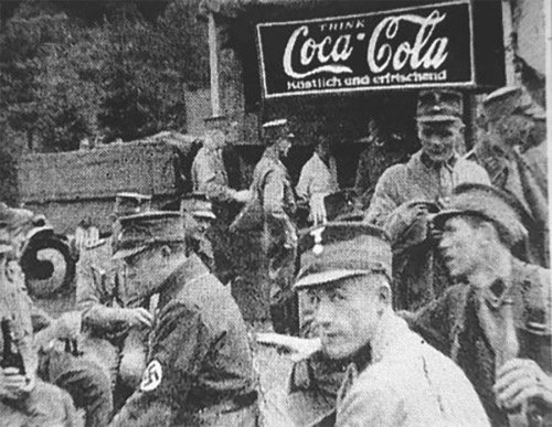 Člani nacistične partije in oglas za Coca-Colo. Ameriška pijača je bila v Nemčiji pred začetkom druge svetovne vojne izredno priljubljena. Coca-Cola je tudi, podobno kot velika druga imena ameriške industrije, tako rekoč do vstopa ZDA v vojno konec leta 1941 v veliki meri "prezrla" agresijo Nemčije nad okoliškimi državami. | Foto: 