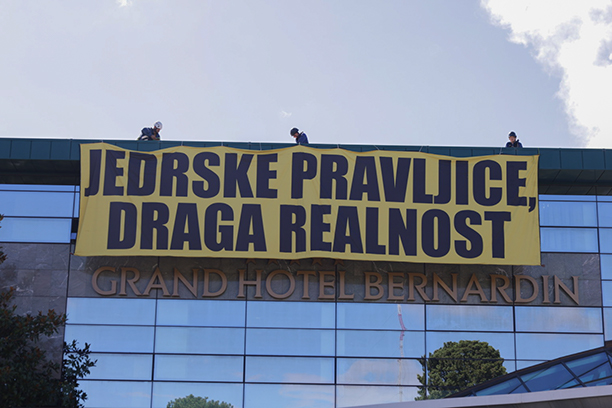 Poleg intervencije pred hotelom je med govorom državnega sekretarja za nacionalni jedrski program Danijela Levičarja Greenpeaceova aktivistika iz Slovenije in Hrvaške razpela transparent s sporočilom Elite fantazirajo, ljudje plačujemo. | Foto: GreenPeace Slovenija