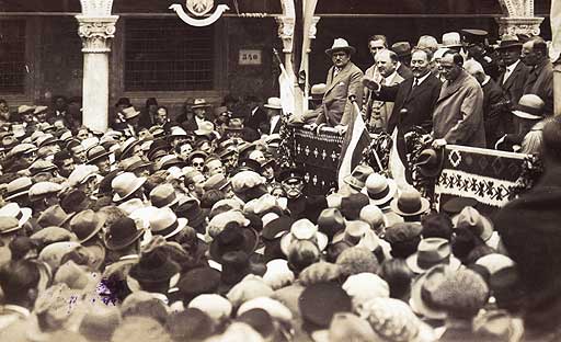 Stjepan Radić V Kraljevini SHS oziroma od leta 1929 Jugoslaviji so imeli politično prevlado Srbi, toda Slovenci smo bili tudi na udaru Hrvatov oziroma Hrvaške kmečke stranke (znana bolj po kratici HSS), ki jo je vodil Stjepan Radić (na fotografiji govornik na odru, ki ima dvignjeno roko). Ta je želel hrvaški vpliv razširiti tudi v Slovenijo, še zlasti v Prekmurje. To mu je preprečil Korošec s svojo Slovensko ljudsko stranko.  | Foto: Wikimedia Commons