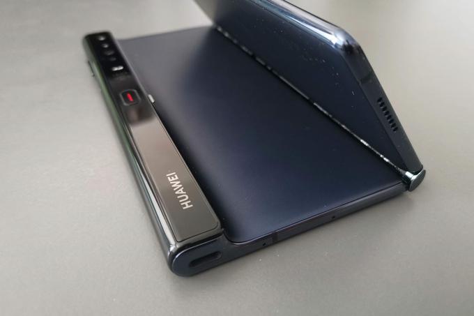 Postopek razpiranja pametnega telefona Huawei Mate Xs začnemo s pritiskom velikega gumba z rdečo črtico, ki sprosti preklopni mehanizem. Na tej fotografiji je sicer vidna ena večjih pomanjkljivosti pametnega telefona Mate Xs - kakorkoli ga obrnemo, se bo z enim zaslonom vselej dotikal površine, na kateri leži. | Foto: Matic Tomšič