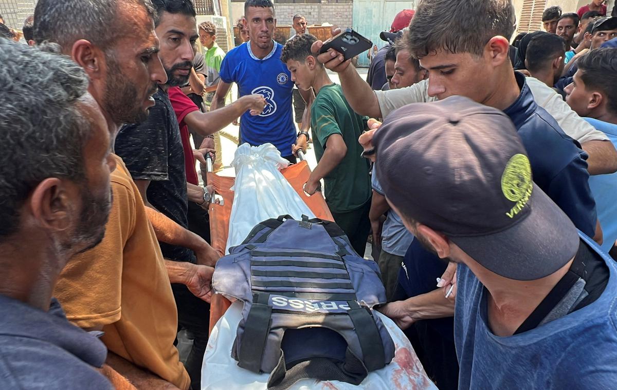 Gaza, ubiti novinar | Odbor za zaščito novinarjev in Novinarji brez meja so pred današnjim napadom sporočili, da je bilo doslej v vojni v Gazi ubitih okoli 200 novinarjev. Med drugim je izraelska vojska v začetku meseca v napadu na šotor, ki ga je v mestu Gaza uporabljala novinarska ekipa, ubila pet sodelavcev Al Jazeere. Napad je sprožil val zgražanja in obsodb. | Foto Reuters