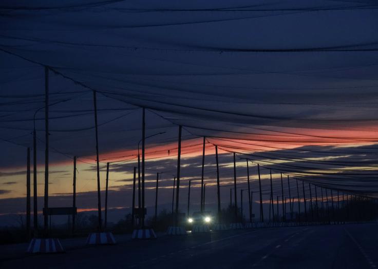 Ceste v okolici Hersona so prepredene z mrežami, ki vozila varujejo pred napadi ruskih brezpilotnih letalnikov.  | Foto: Reuters