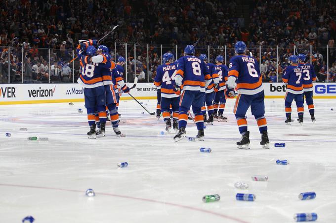 Navijači NY Islanders so po veliki zmagi odvrgli na led kar nekaj pločevink piva.  | Foto: Reuters