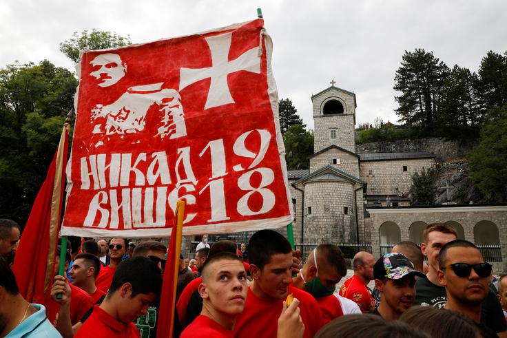 Protest Črnogorcev na Cetinju Črnogorska nacionalna čustva so najmočnejša v Cetinju in njegovi okolici. Na tem območju se je konec 17. stoletja oblikovala od Turkov dejansko neodvisna pravoslavna teokratska državica. Mednarodno priznana je postala na berlinskem kongresu leta 1878. Leta 1910 je postala kraljevina. Leta 1918, ko je Črno goro vojaško zasedla srbska vojska, je tako imenovana podgoriška skupščina razglasila priključitev k Srbiji. Ta odločitev je travma za črnogorske zagovornike neodvisnosti od Srbije. Po letošnjih volitvah, ko je Đukanovićev blok strank izgubil večino, so bili na Cetinju protesti (na fotografiji). Eden od protestnikov nosi rdečo zastavo z napisom v cirilici, ki se v slovenščini glasi Nikdar več 1918. Na zastavi je tudi podoba Krsta Popovića, vojaškega voditelja upora proti priključitvi k Srbiji. Prav zaradi strahu pred ponovitvijo leta 1918 se je pred dnevi odhajajoča črnogorska vlada tako jezno odzvala na besede srbskega veleposlanika v Črni gori Vladimirja Božovića, ki je javno zagovarjal odločitev podgoriške skupščine o priključitvi k Srbiji. | Foto: Reuters