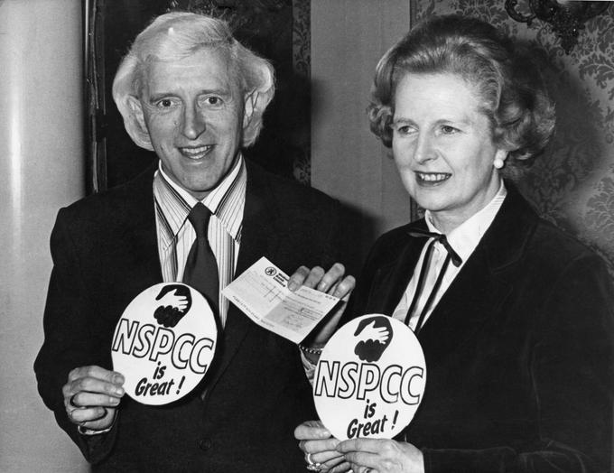 Takole se je zloglasni britanski pedofil Jimmy Savile leta 1980 nastavljal fotografom ob takratni britanski premierki Margaret Thatcher, ko je prav društvu NSCPP prispeval nekaj denarja. | Foto: Guliverimage/Getty Images