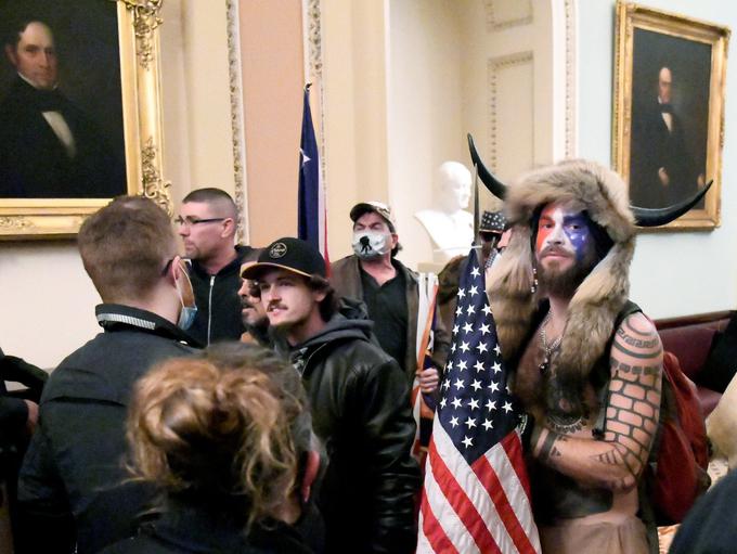 Trumpovi privrženci so 6. januarja letos vdrli v ameriški kongres. Med njimi je bil tudi možakar z vzdevkom Qanon šaman, oblečen v nekakšno vikinško-indijansko opravo. | Foto: Reuters