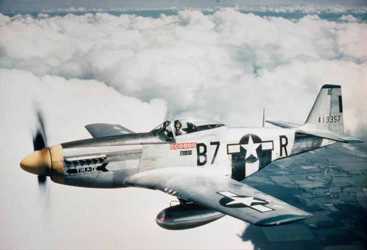 Poročnik Vernon R. Richards iz svojega lovca P-51D mustang pozdravlja posadko bombnika, ki ga spremlja na misijo, 1944.  | Foto: Britanski Imperialni vojni muzej (IWM)